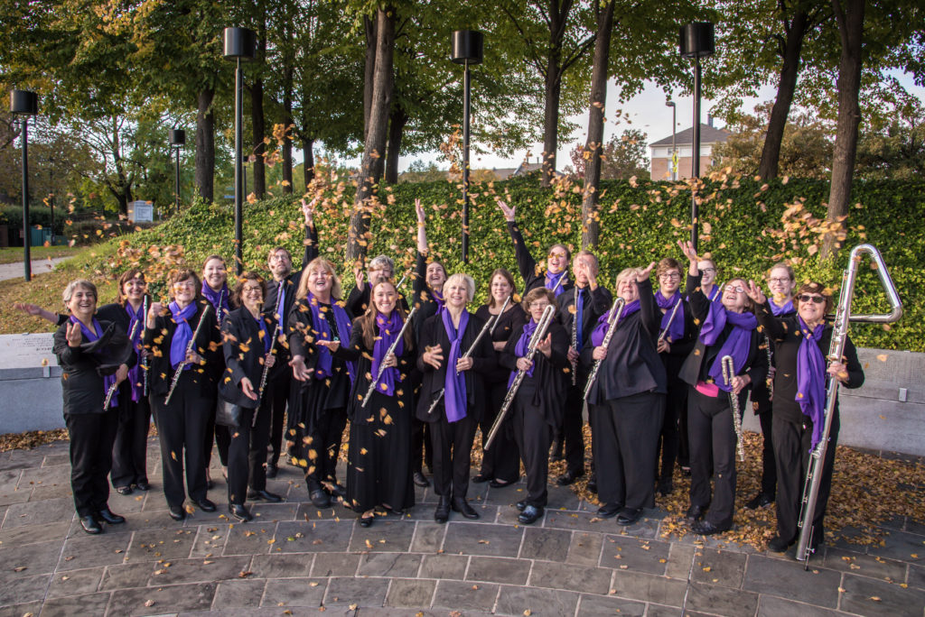 Baltimore Flute Choir holding flutes of various sizes and tossing leaves